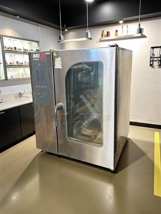 Industrial BKI oven in stainless steel, with glass door and control panel; used condition, with visible label marking the brand.