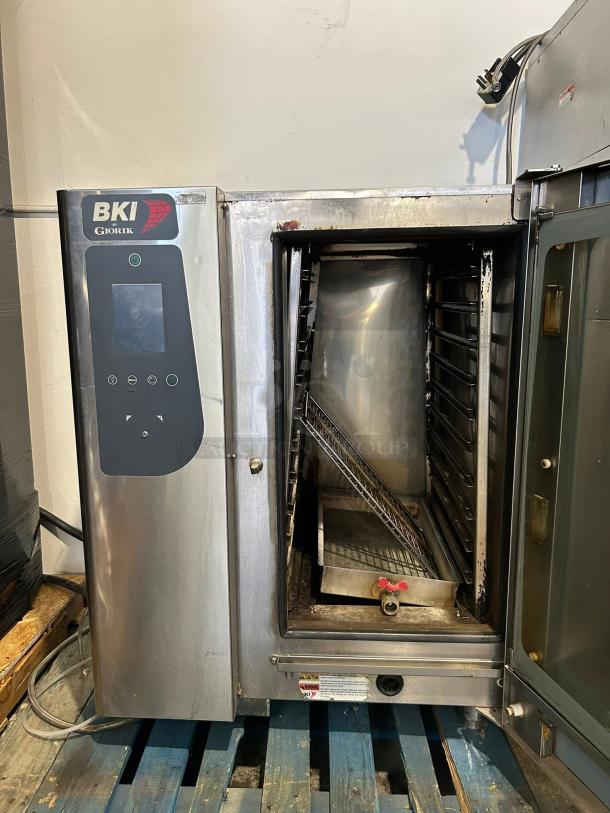 BKI Giorik commercial oven, stainless steel, touchscreen controls, used condition, visible wear, sitting on blue pallets.