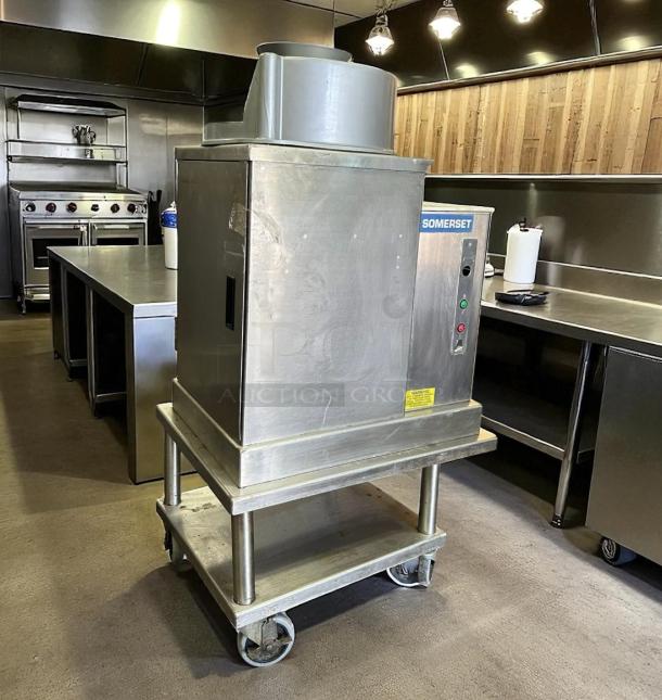 Somerset dough sheeter machine in stainless steel, good condition. Features control panel, mounted on a wheeled stand.