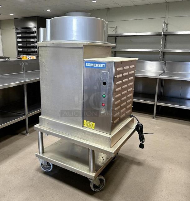 Somerset dough sheeter, model 135, stainless steel, on a mobile cart with power cord; excellent condition, used in kitchen setting.