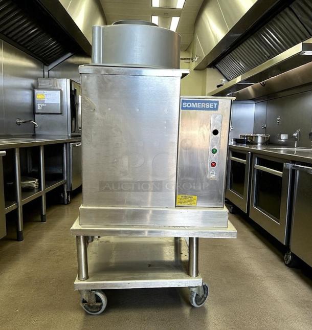 Stainless steel Somerset dough roller in commercial kitchen, model 135. Features control panel, on mobile stand, good condition.
