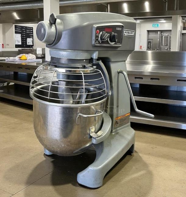 Hobart HL200 mixer, commercial-grade, grey, 20-quart stainless steel bowl, speed control dial, safety guard.