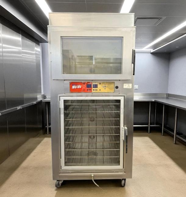 NU-VU commercial oven with glass door, control panel, and multiple shelves. Features caster wheels. Used kitchen equipment.