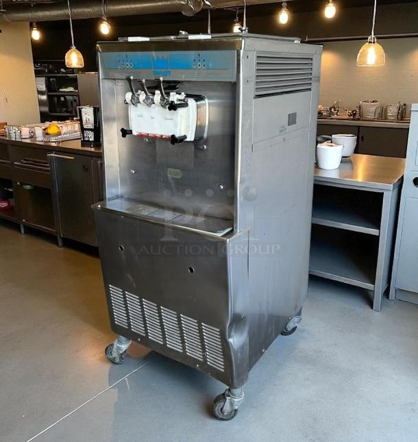 Taylor 3-head commercial soft serve machine, stainless steel, on casters, in good condition, minor exterior dents.