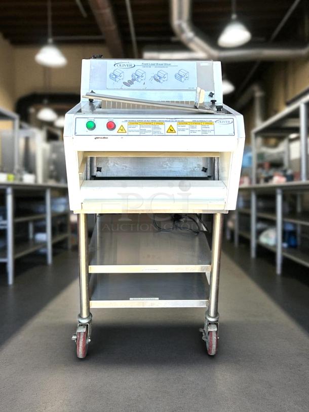 Oliver front load bread slicer, model 139, in used condition. Features control panel with buttons, warning labels, on rolling cart.