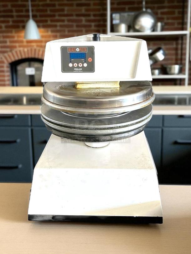 Proluxe DP3300 pizza dough press in good condition, Blaze Pizza branding; stainless steel plates, digital controls.