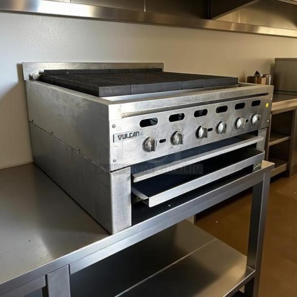 Vulcan commercial gas range with six control knobs, stainless steel, used condition, visible branding on front panel.
