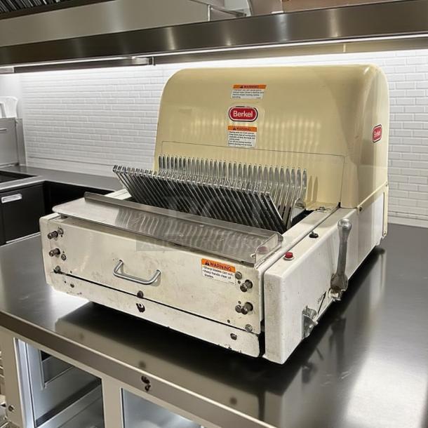 Berkel commercial bread slicer, model 149, in good condition, features sharp blades and safety warnings, ideal for bakery use.
