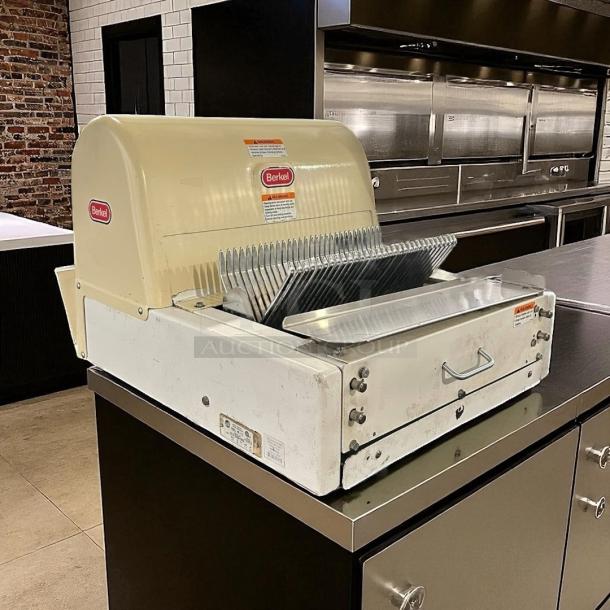 Berkel commercial bread slicer, model 149, in used condition. Visible safety warnings and Berkel branding on top panel.