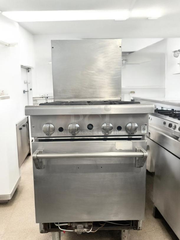 Commercial 4-burner gas range with oven, stainless steel, excellent condition, fully tested and working.