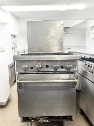 Commercial 4-burner gas range with oven, stainless steel, excellent condition, fully tested and working.