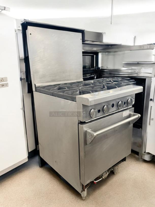 Commercial 4-burner gas range with standard oven, stainless steel, excellent condition, fully tested, working model.