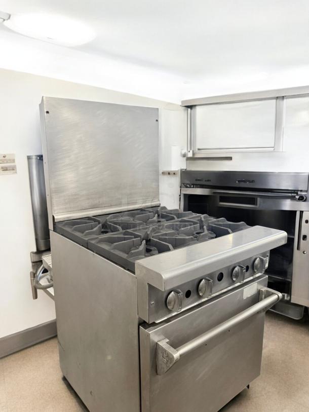Commercial 4-burner gas range with standard oven in excellent condition, stainless steel, fully tested, working model.