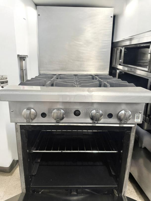 Commercial 4-burner gas range with standard oven in stainless steel. Excellent condition, fully tested.