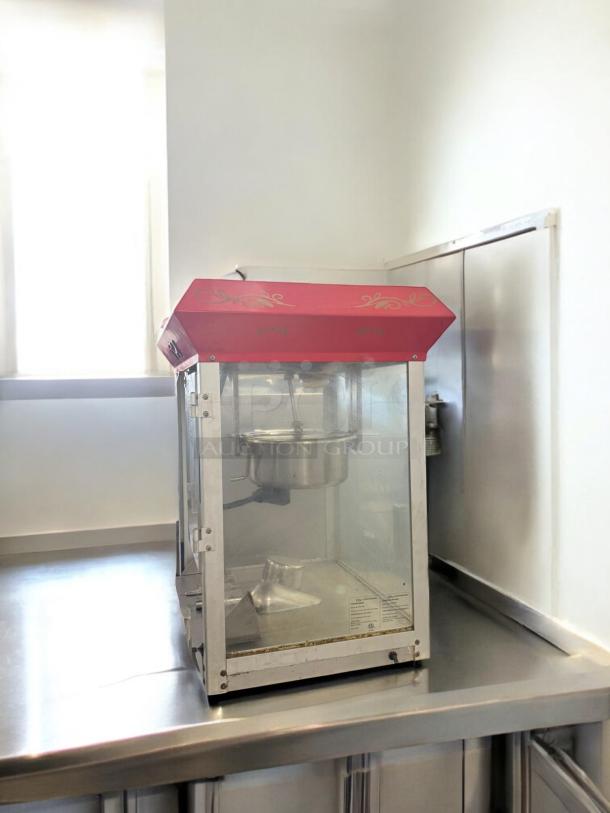 Commercial Grade countertop popcorn maker, 120V, excellent condition, fully tested, clear glass with red top, visible controls.