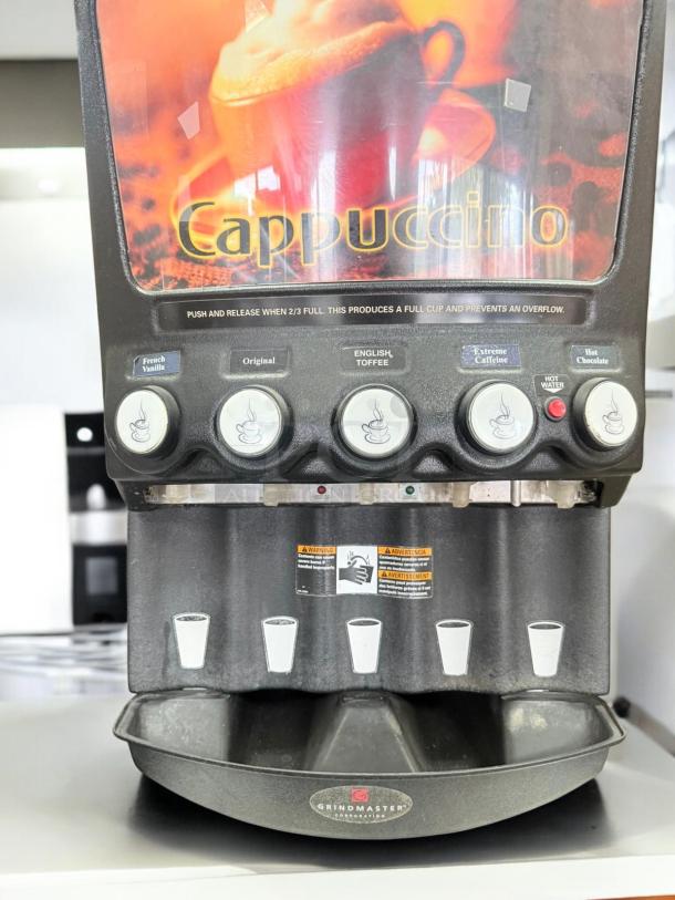 Grindmaster 5-Flavor Cappuccino Dispenser, excellent condition, 120V, fully tested, automatic controls, warning labels visible.
