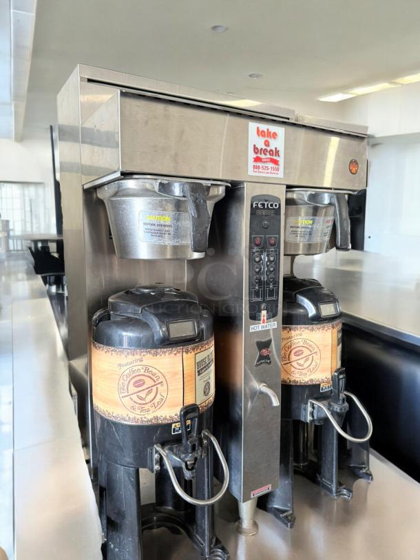 Fetco CBS-2131XTS dual coffee brewer in excellent condition, 120/240V. Features digital controls, dual urns, and safety labels.
