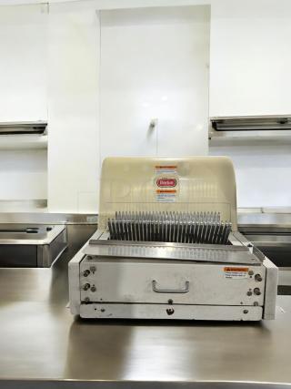 Berkel MB 1/2 bread slicer in excellent condition, 115V. Features sharp blades, visible warning labels, fully tested and working.