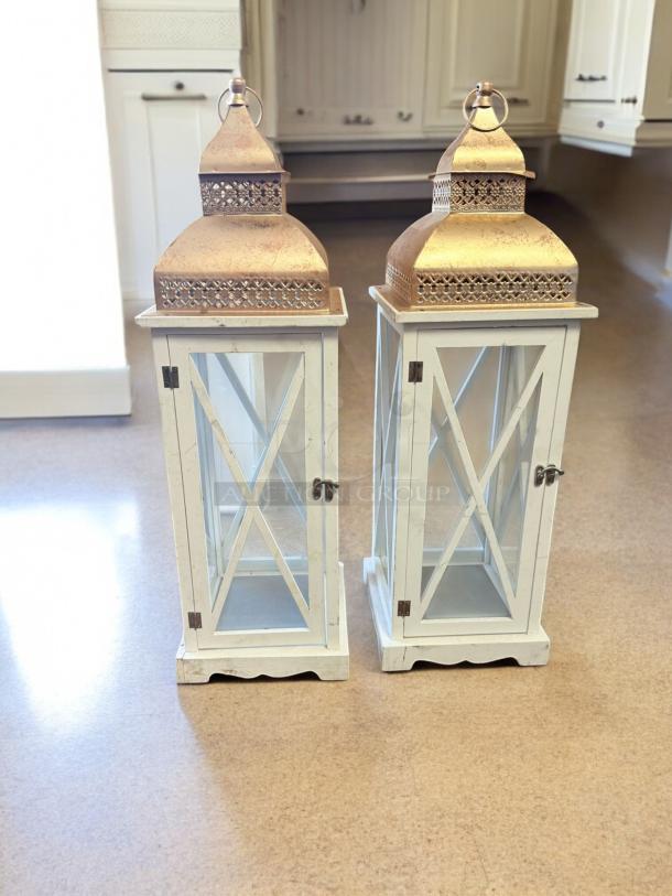 Pair of Moroccan-style lanterns in excellent condition, featuring white wood frames and ornate gold metal tops.