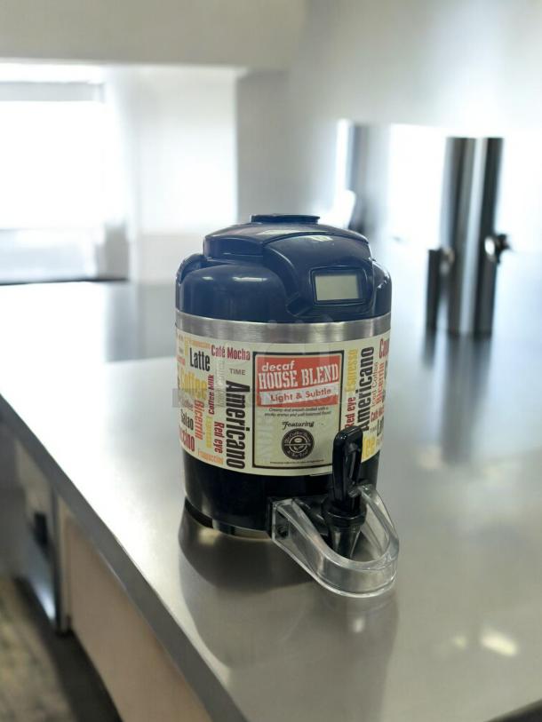 Black insulated coffee airpot dispenser in excellent condition, tested and working, with decorative text labels.