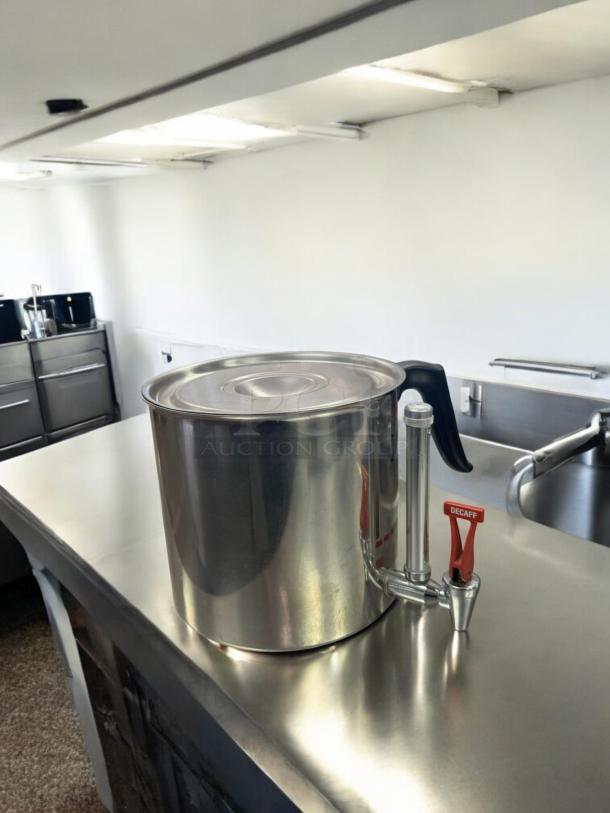 Stainless steel coffee dispenser in excellent condition with manual faucet, labeled "Decaf." Fully tested and working.