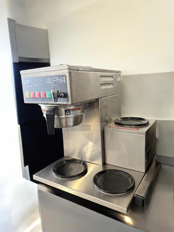 Curtis ALPHA 3DR coffee brewer in excellent condition, fully tested; features 120V operation with dual warmers and control panel.