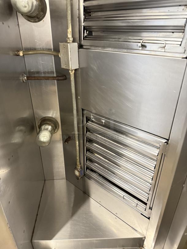 Stainless steel hood system in excellent condition, like new, with multiple vents and clean surfaces.