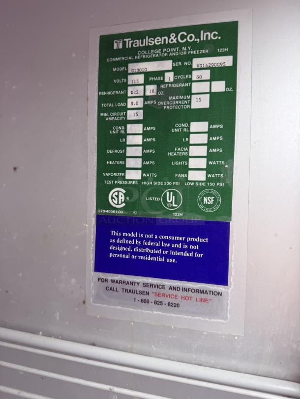 Traulsen G10010 refrigerator label showing model details, voltage, refrigerant type, and service hotline.
