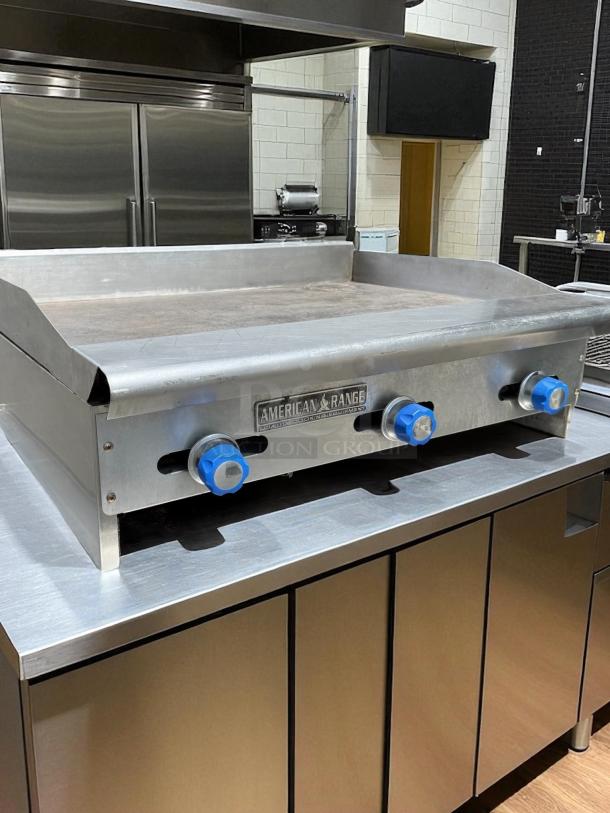American Range 36” gas griddle in excellent condition, tested and working, with stainless steel finish and control knobs.