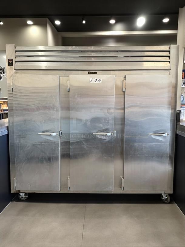 Traulsen RLT332WUT-FHS stainless steel three-section reach-in freezer. Tested, working, 79 Cu. Ft., solid doors, on wheels.