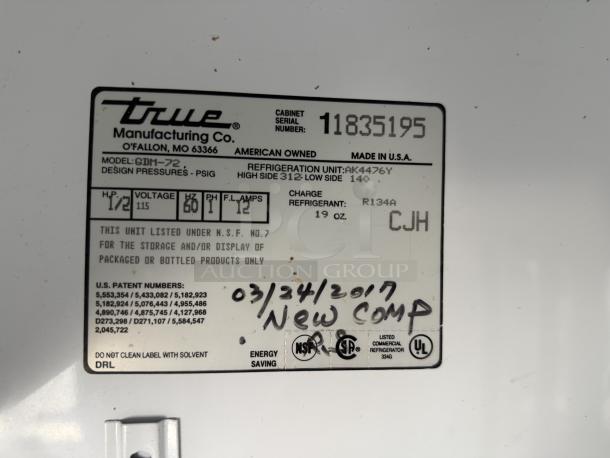 Label of True Manufacturing GDM-72 glass door merchandiser, model GDM-72, voltage 115, NSF listed, made in USA.