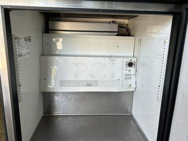 True TWT-27F-HC 28" worktop freezer interior, excellent condition, visible label details, and shelving supports.