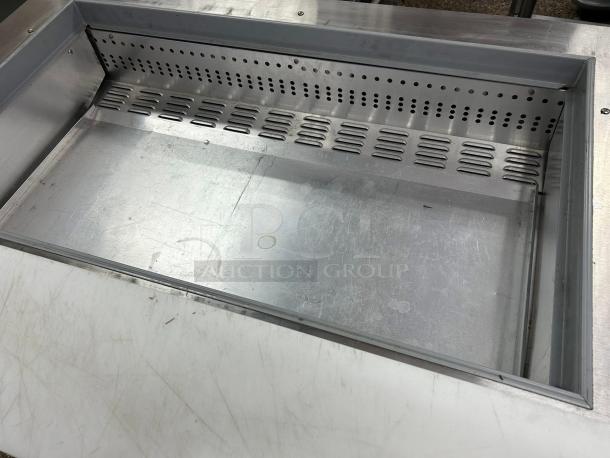 Continental Refrigerator SW48-N-18M sandwich prep table interior, showing stainless steel surface and vented panel.