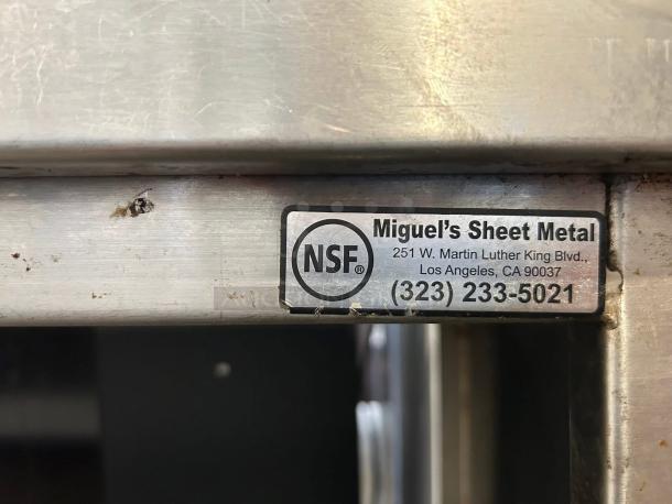 Stainless steel 73" custom-made table, sturdy and reliable. Label shows NSF, Miguel's Sheet Metal, Los Angeles contact info.