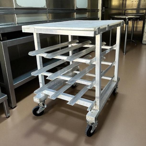 New Age half-size mobile aluminum can rack for #10 and #5 cans in great condition. Features sturdy casters for easy mobility.