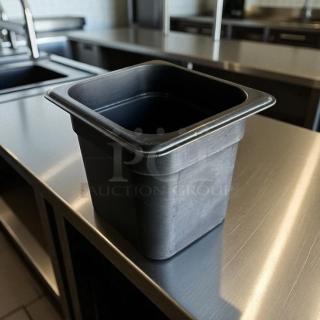 Cambro black 1/6 size deep food storage container, 6 in deep, clean and compact, on stainless steel surface.
