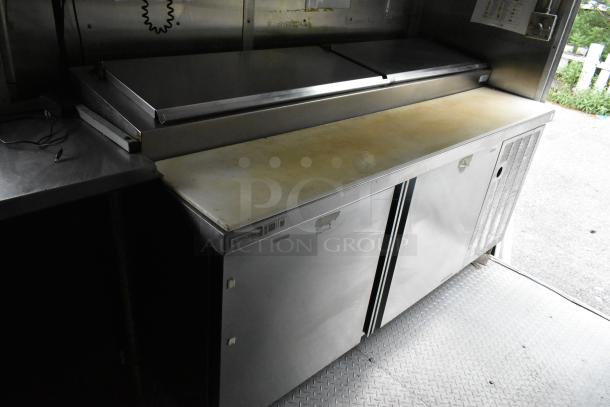 Fully equipped mobile kitchen trailer with prep tables, coolers, and freezers. Includes Delfield appliance. Ideal for startup.