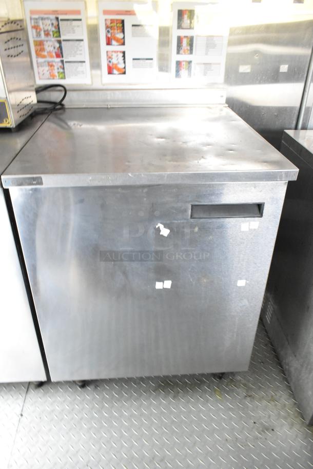 Fully equipped former Popeyes food trailer interior, featuring a stainless steel cooler or freezer unit. Sturdy, ready for use.