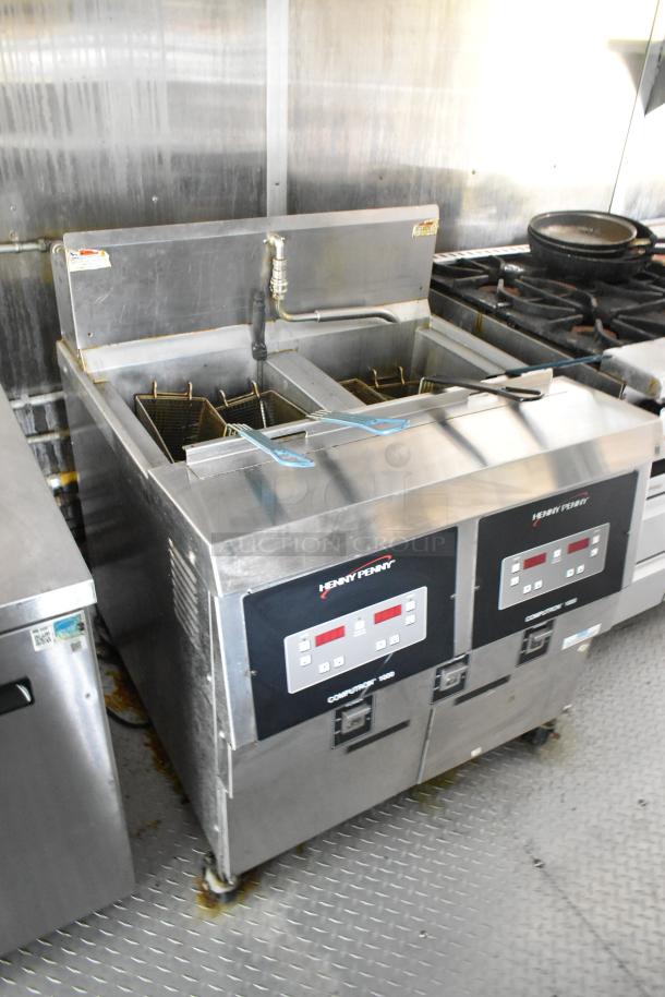 Former Popeyes food trailer interior with Henny Penny 2-bay fryer, grease hood, gas range, and prep area.