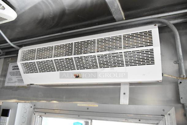 Interior view of the former Popeyes food trailer featuring an overhead air conditioning unit and visible wiring.