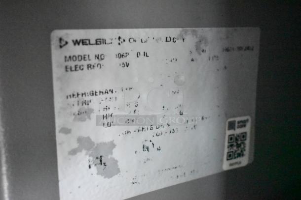 Blurred label on mobile kitchen equipment featuring Welbilt's model and electrical specifications. Some text is obscured.