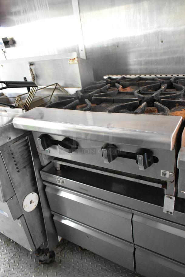 Former Popeyes food trailer kitchen interior showing stainless steel range and dual fryer setup, ideal for startup.