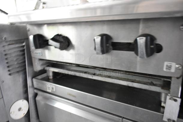 Commercial kitchen appliance with multiple control knobs in used condition, part of a fully outfitted former Popeyes food trailer.