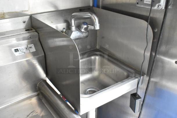 Stainless steel sink in former Popeyes food trailer, featuring Boos 1005 label, faucet, and splash guard, in clean condition.