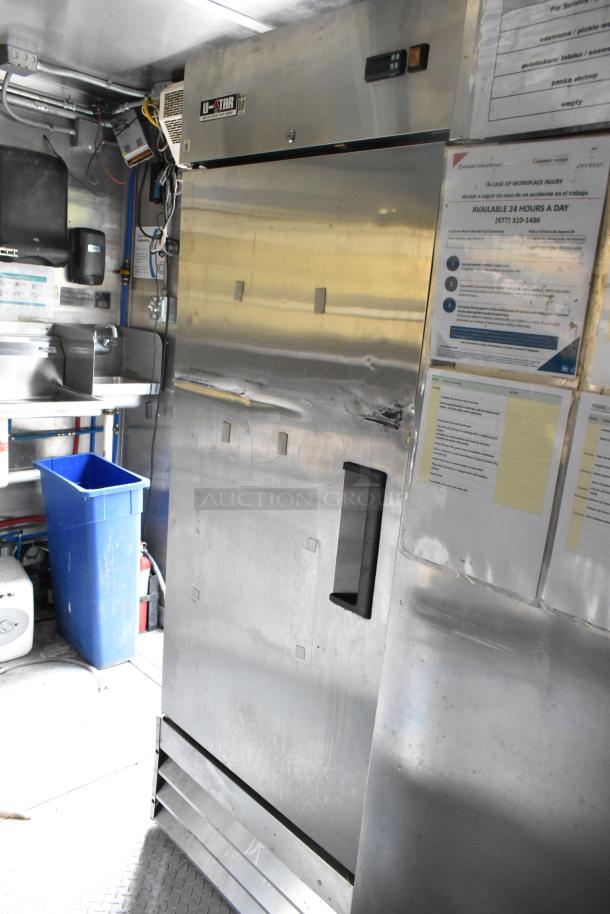 Mobile kitchen interior featuring a U-Star fridge, sink, blue trash bin, and posted instructions. Suitable for ghost kitchen use.