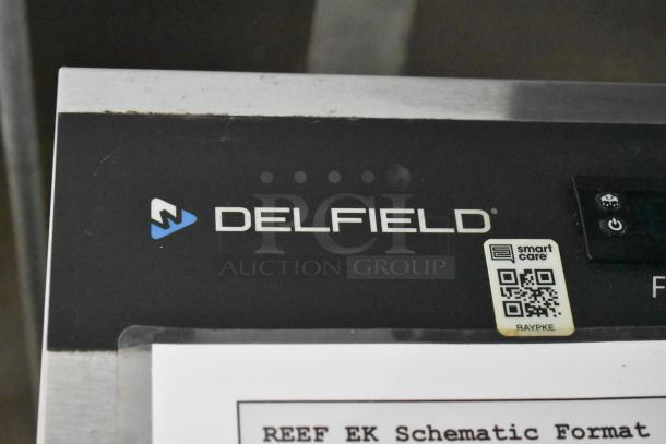 Delfield cooler with Smart Care label and QR code, part of a former Popeyes food trailer setup, ready for mobile kitchen use.