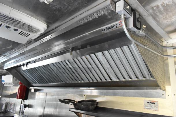 Stainless steel kitchen hood in fully outfitted former Popeyes food trailer, includes fire suppression system and signage.