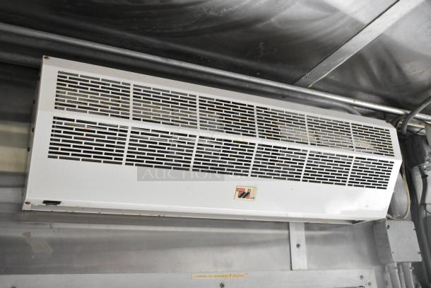 Air conditioning unit inside fully equipped mobile kitchen trailer, featuring a vented front panel and a manufacturer's label.