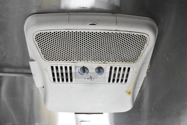Ceiling-mounted Dometic air conditioning unit in a mobile kitchen, showing control knobs and vents. Slightly worn condition.