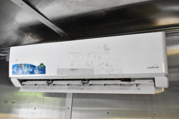 Airomatic inverter air conditioner unit mounted on the interior of a food trailer ceiling, showcasing slight wear.